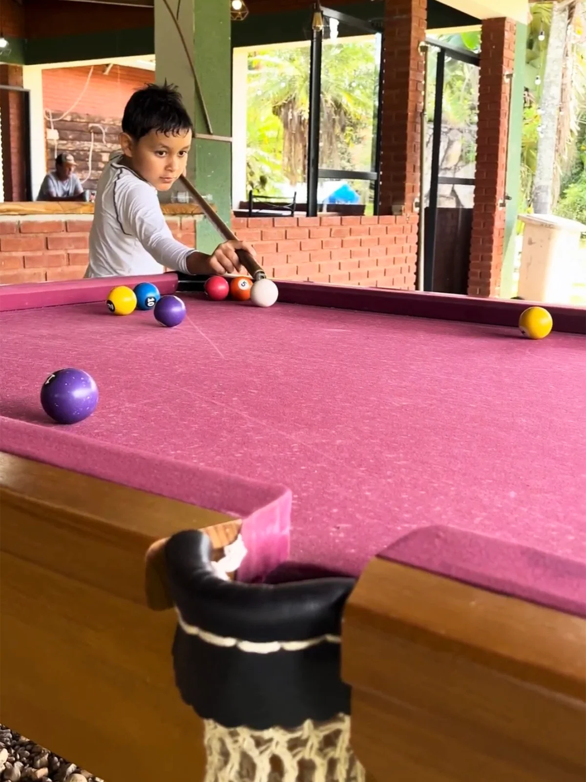 Criança jogando sinuca no Park dos Lagos